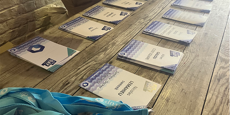 des badges pour l'AFUP Day 2024 Lille sont disposés sur une table, en attente de leurs propriétaires